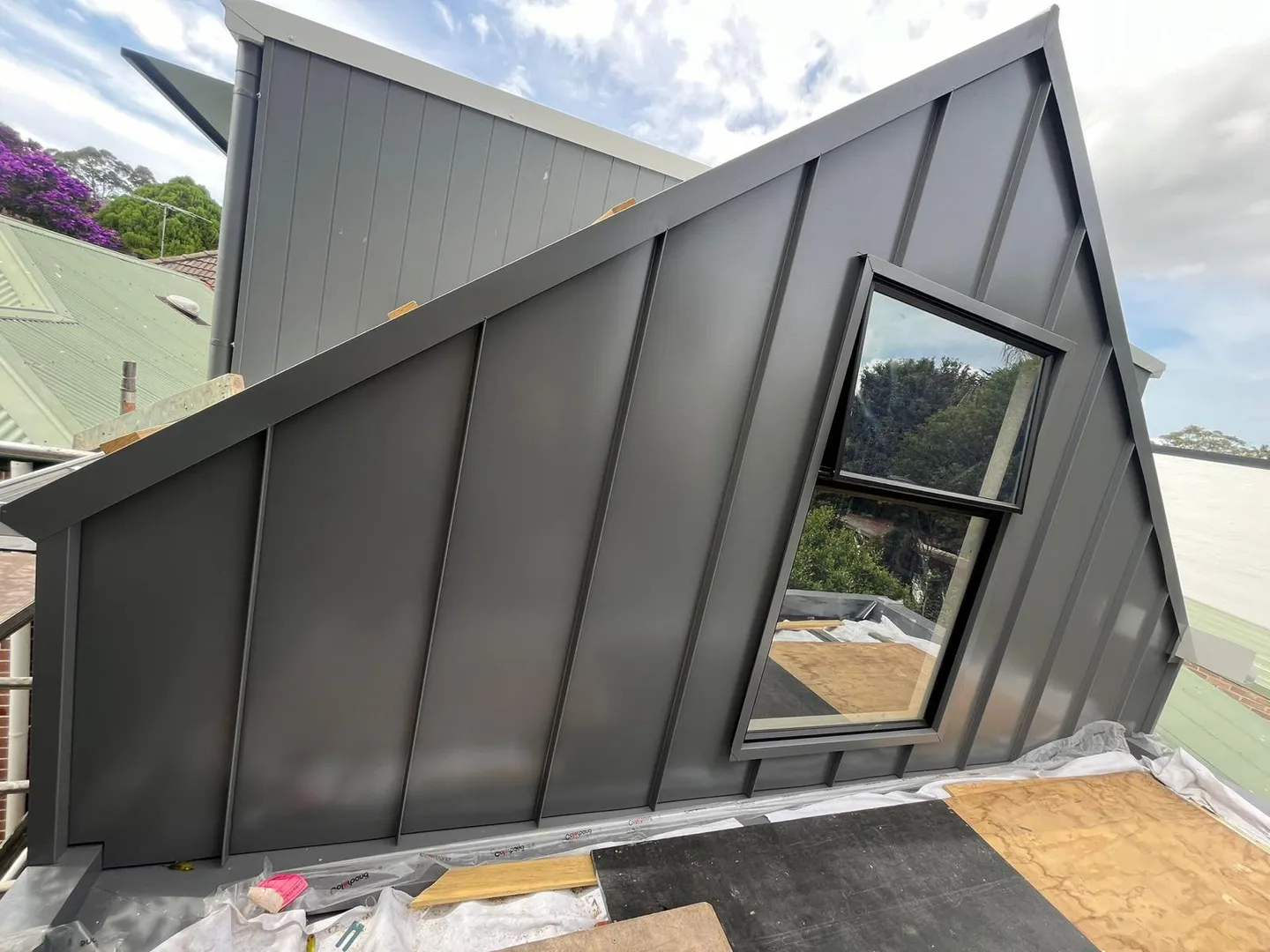 Modern rooftop with black cladding and window.