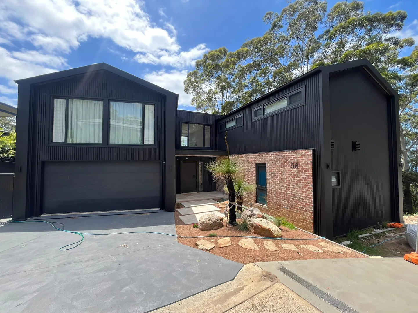 Modern black house with large windows and driveway