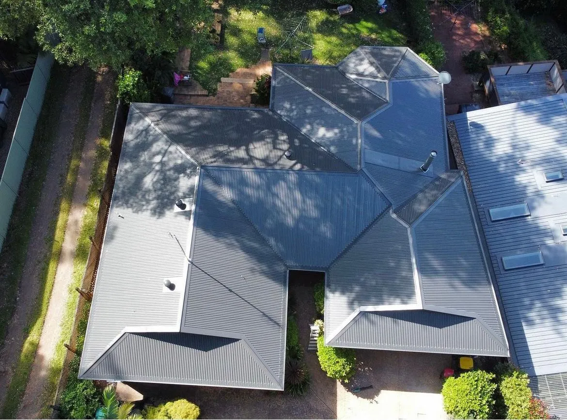 Aerial view of a house with a complex roof design.